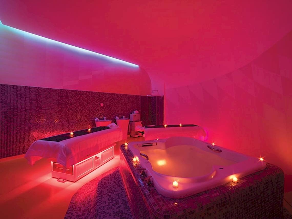 Spa-Bereich im Temptation Cancun Resort mit zwei Behandlungstischen und einer großen Badewanne.