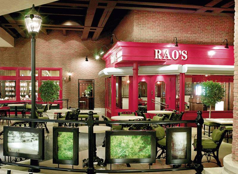 Innenansicht des Rao's Restaurants im Caesars Palace mit roten Wänden, grünen Stühlen und Tischen.