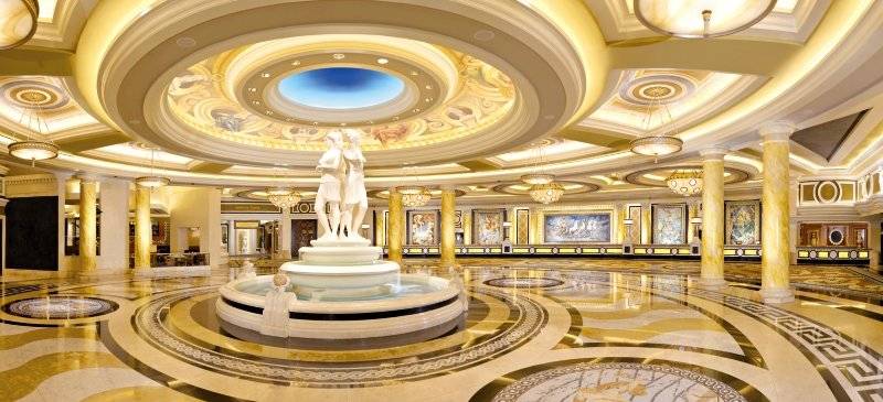 Innenbereich des Caesars Palace mit einer großen Brunnenskulptur und goldenen Säulen.