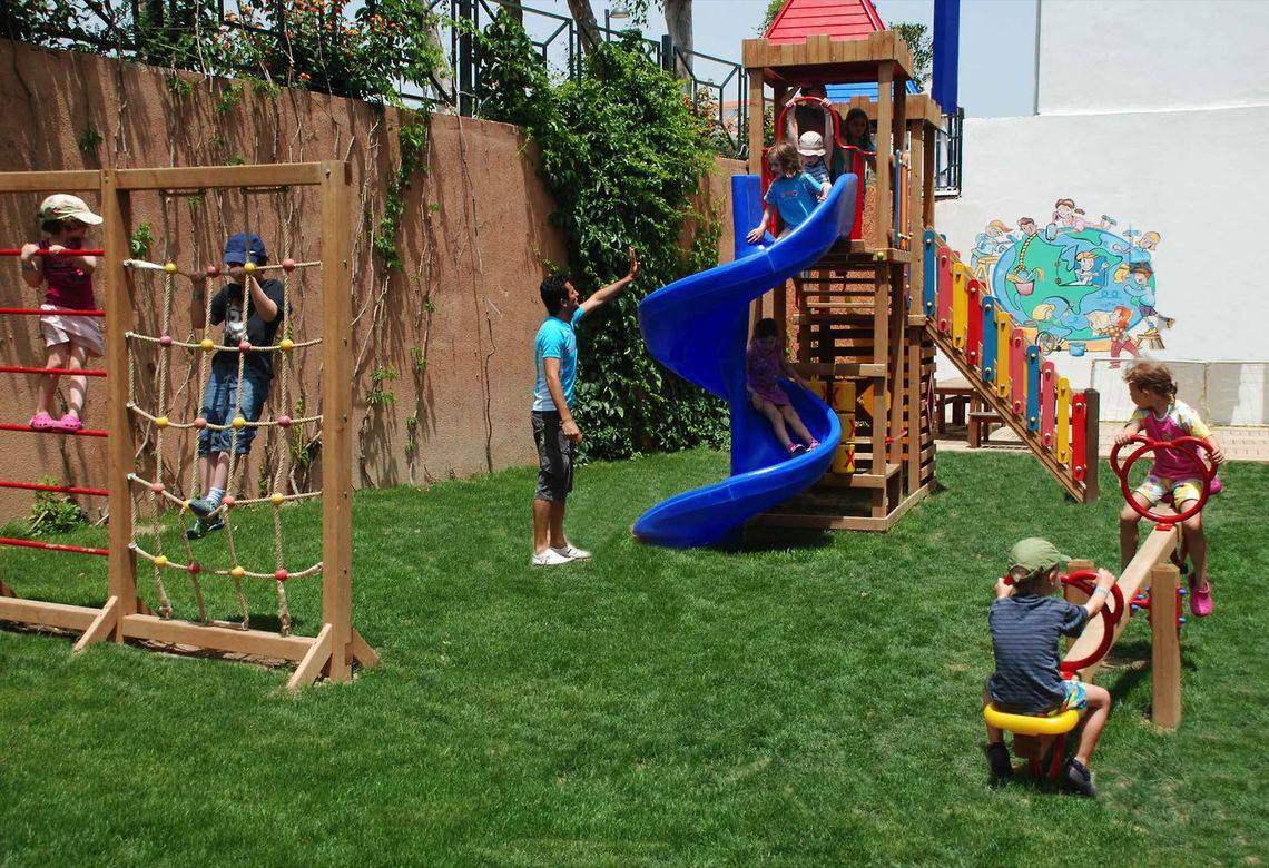 Kinder spielen auf einem Spielplatz im Freien im Monachus Hotel & Spa.