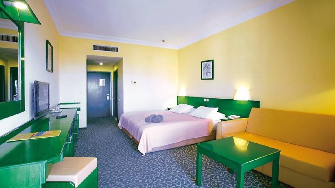 Hotelzimmer im Miramare Beach Hotel mit gelb und grüner Inneneinrichtung