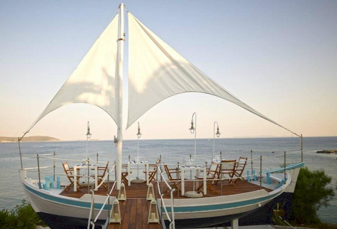 Bootsrestaurant im Proteas Blu Resort mit Tisch und Stühlen am Meer
