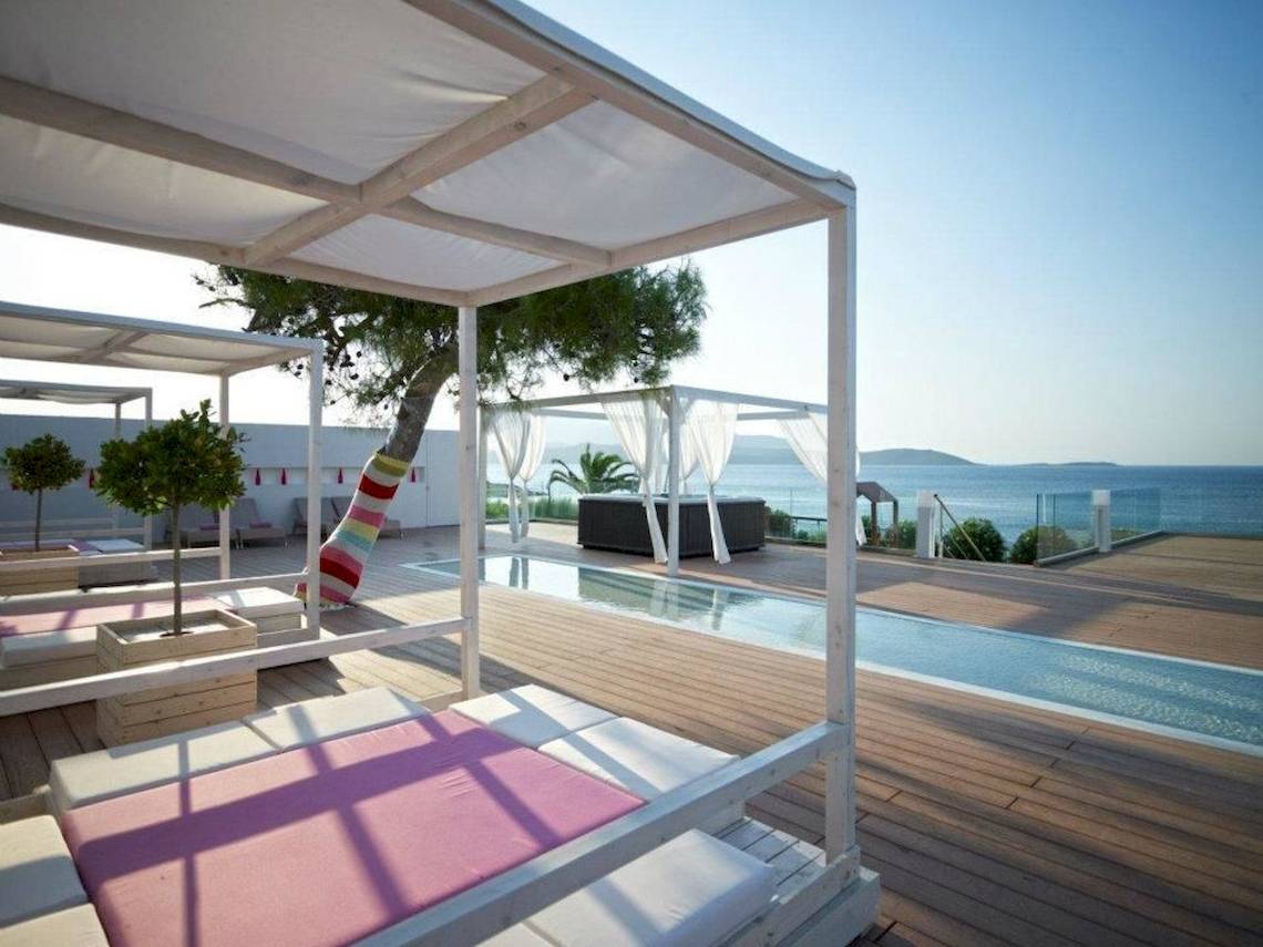 Terrasse des Proteas Blu Resorts mit Liegen und Pool am Meer