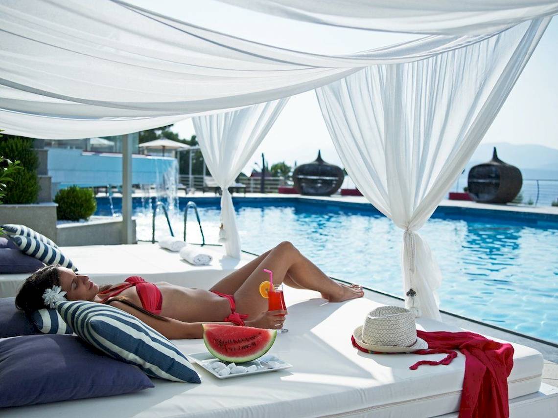 Frau im roten Bikini am Pool unter Baldachin im Proteas Blu Resort