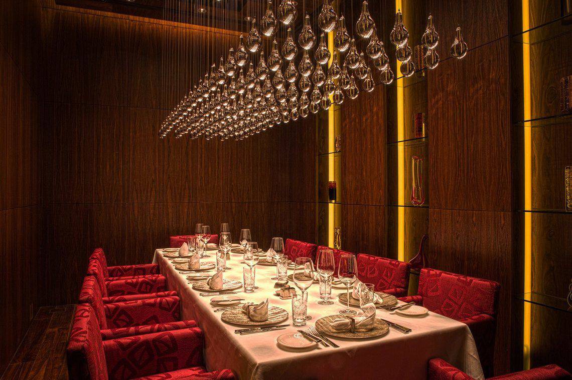 Das Esszimmer des Ritz Carlton Abu Dhabi Grand Canal mit rotem Interieur und hängenden Lampen.