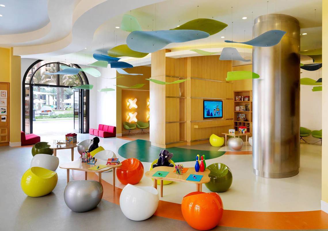 Kinderbereich im Ritz Carlton Abu Dhabi Grand Canal mit bunten Sitzmöbeln und Spielzeug.