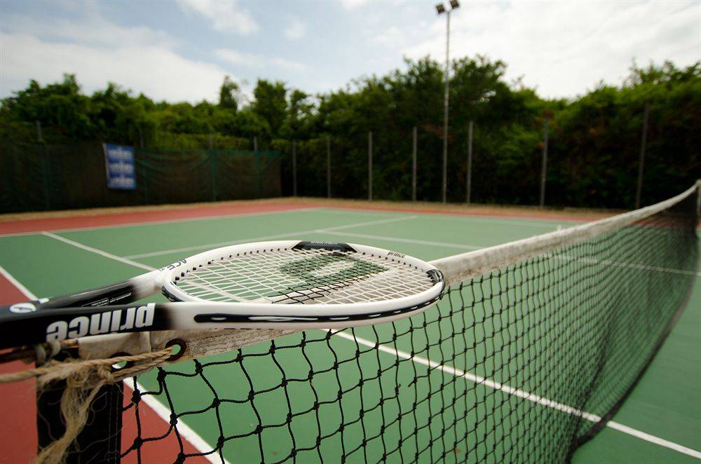 Tennisplatz im Bluebay Beach Resort & Spa mit Netz und Schläger.