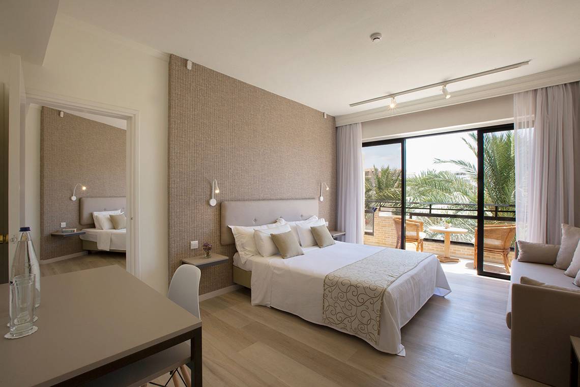 Schlafzimmer im Venus Beach Hotel mit Balkon und Blick auf die Palmen