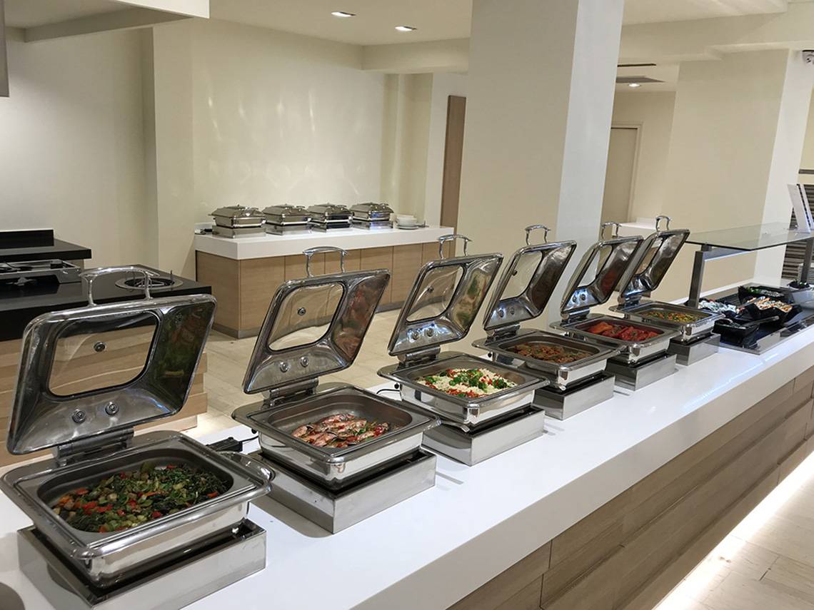 Buffet-Tisch im Aphrodite Beach Club Hotel mit verschiedenen Speisen in Silberschüsseln.