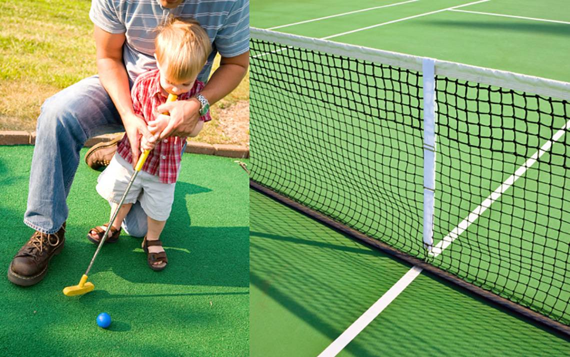 Vater und Sohn spielen Golf auf einem Freiluft-Golfplatz mit einem Netz und einem blauen Ball.