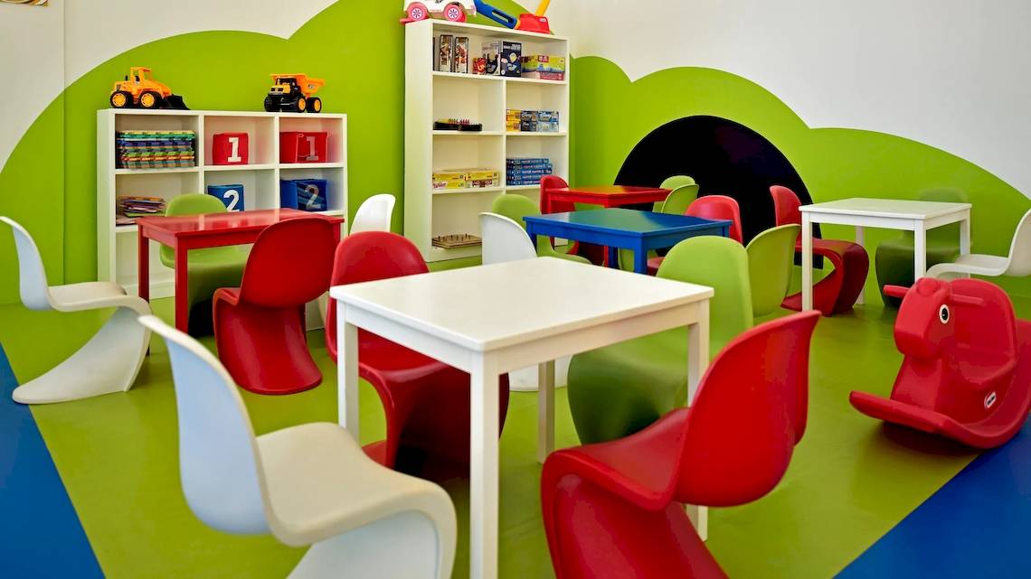 Kinderspielzimmer im Iberostar Costa Dorada Hotel mit bunten Möbeln und Spielzeug.
