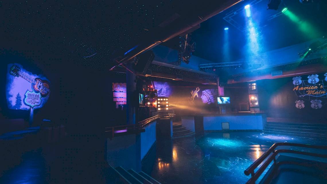 Nachtclub im Iberostar Costa Dorada Hotel mit blauer und grüner Beleuchtung und Musikinstrument-Designs an der Wand.