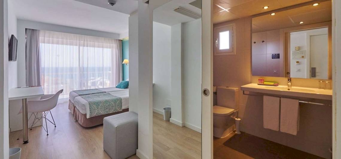 Hotelzimmer im BQ Apolo mit zwei Betten, Schreibtisch, Stuhl, und Meerblick.