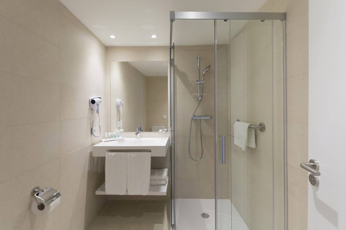 Badezimmer des HSM Linda Playa Hotels mit Dusche, Waschbecken und Handtuchtrockner.