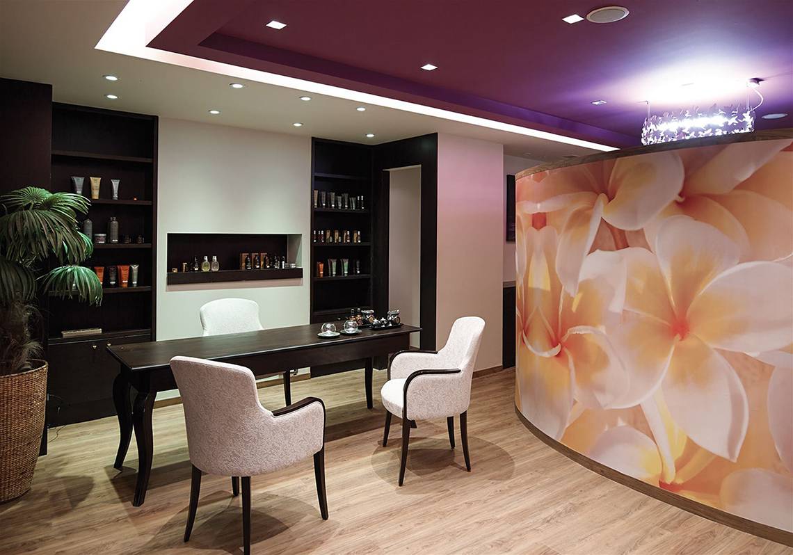 Innendesign des Atlantica Kalliston Resorts mit Esstisch, Stühlen und Blumenwand