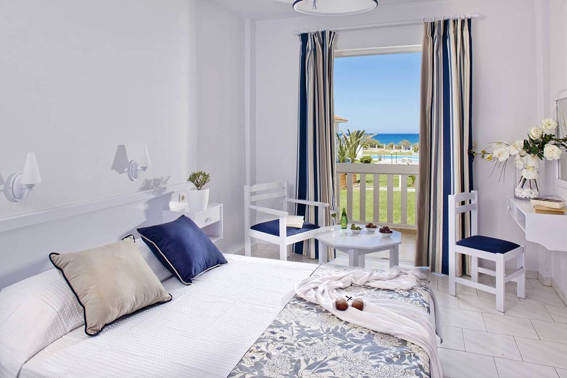 Das geschmackvoll eingerichtete Zimmer im Mrs Chryssana Beach Hotel mit Blick auf den Balkon und das Meer.