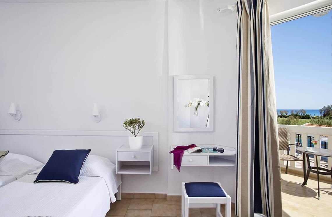 Zimmer im Mrs Chryssana Beach Hotel mit Balkon, Blick auf das Meer und Einrichtung.
