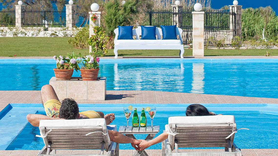 Zwei Leute entspannen sich im Swimmingpool des Mrs Chryssana Beach Hotels.