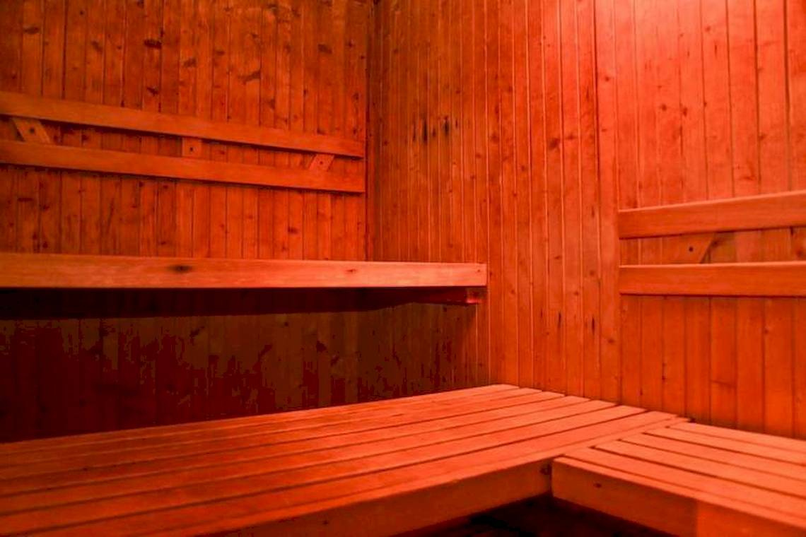 Sauna im Dreams Flora Resort & Spa mit hölzernen Wänden und Bänken.