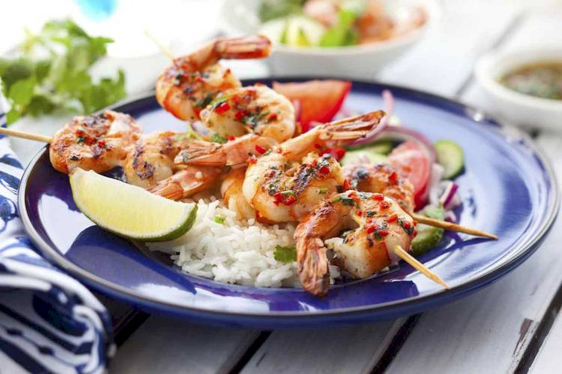 Gegrillte Garnelen auf einem Teller mit Reis und Gemüse