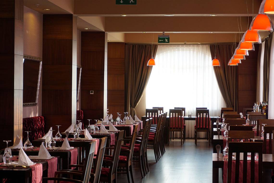 Restaurant des Megasaray Club Belek mit gedeckten Tischen und Stühlen.