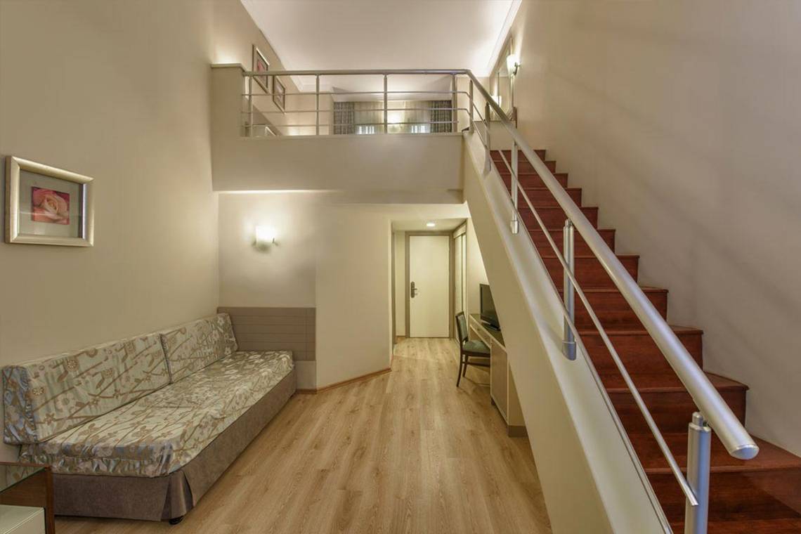 Innenansicht des Megasaray Club Belek mit Sofa und Treppe.