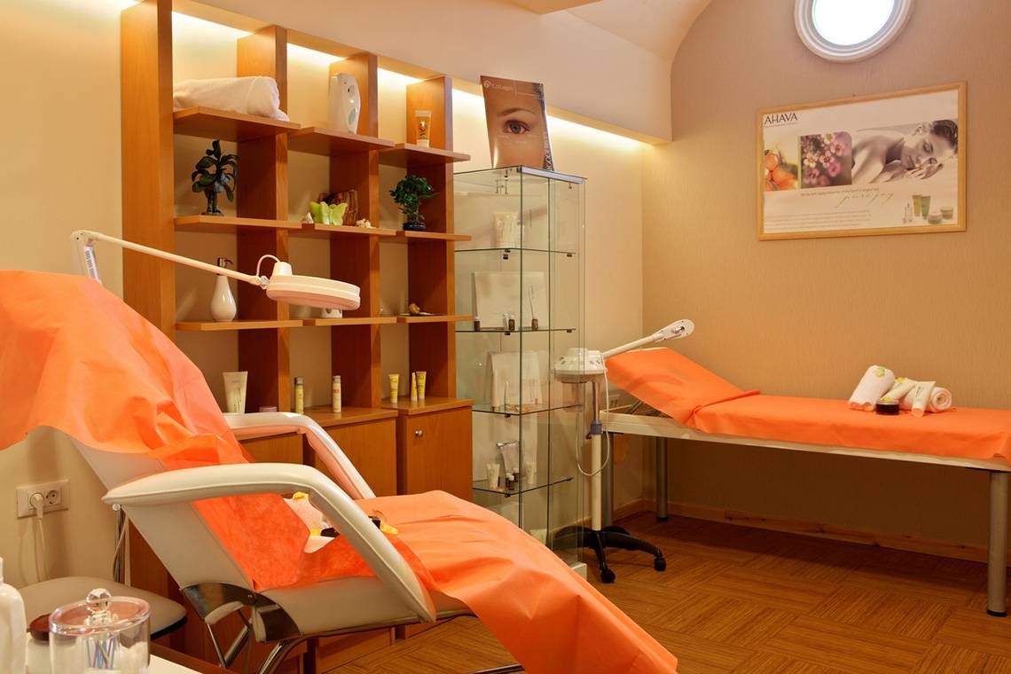 Behandlungsraum im Lesante Classic Luxury Hotel & Spa mit orangefarbenen Stühlen und Behandlungstischen.