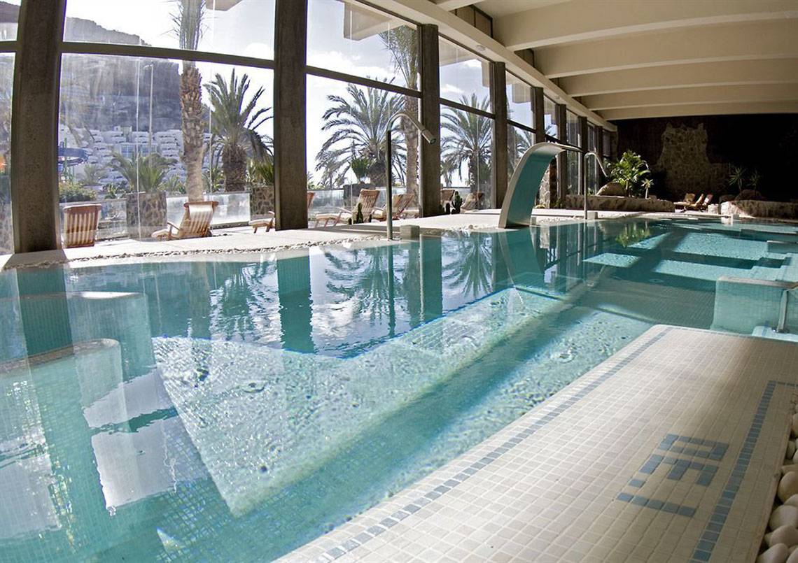 Innenpool im LIVVO Costa Taurito Hotel mit blauem Wasser und blau-weißen Kacheln.