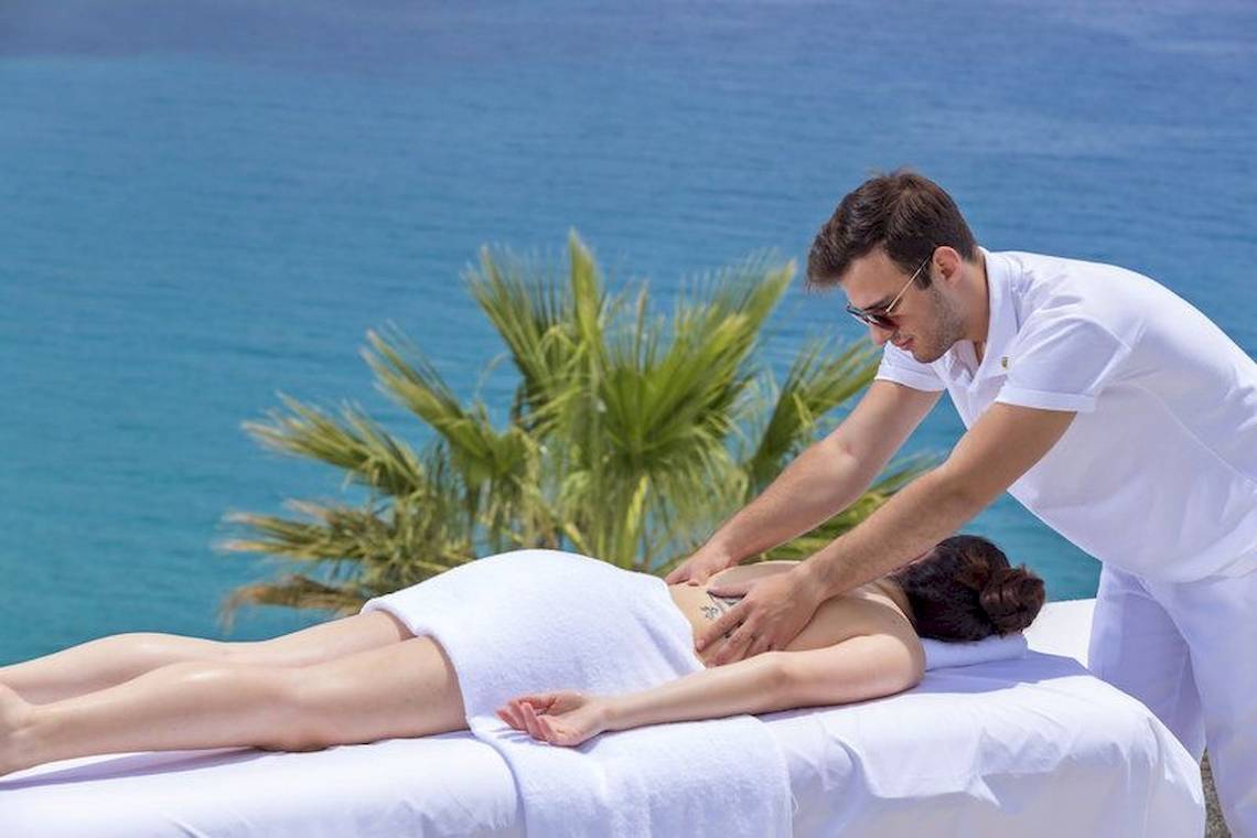 Mann gibt Frau am Strand eine Massage im Pietra E Mare Mykonos Hotel