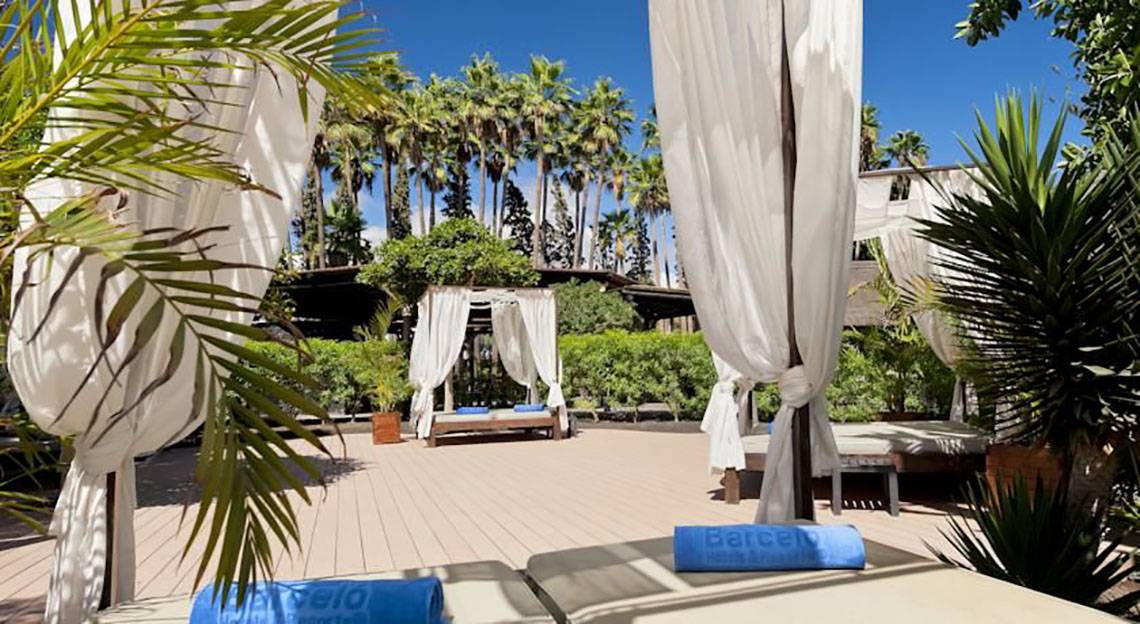 Außenbereich des Barcelo Margaritas Hotels mit Lounge-Bereichen und üppiger grüner Vegetation.