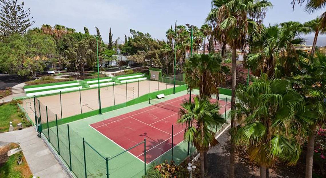 Tennisplatz im Freien des Barcelo Margaritas Hotels mit roten und grünen Feldern und Palmen.