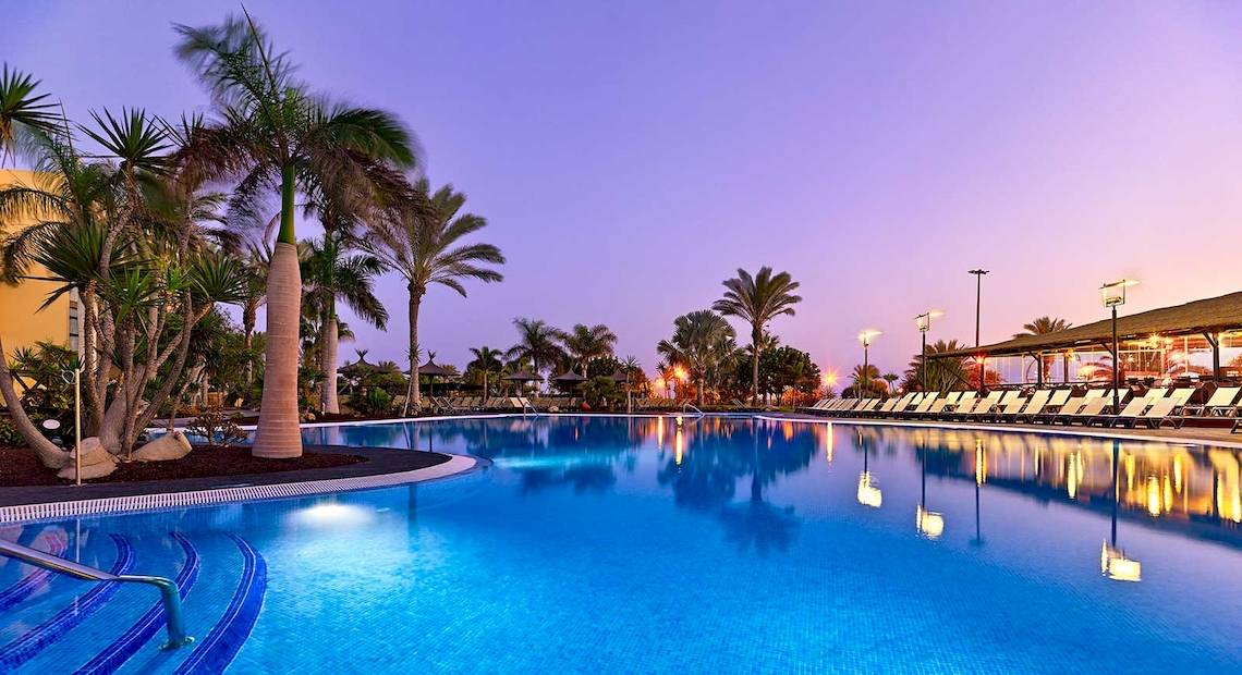 Außenpool des Barcelo Fuerteventura Mar Hotels bei Nacht mit Lounge-Liegen und Palmen