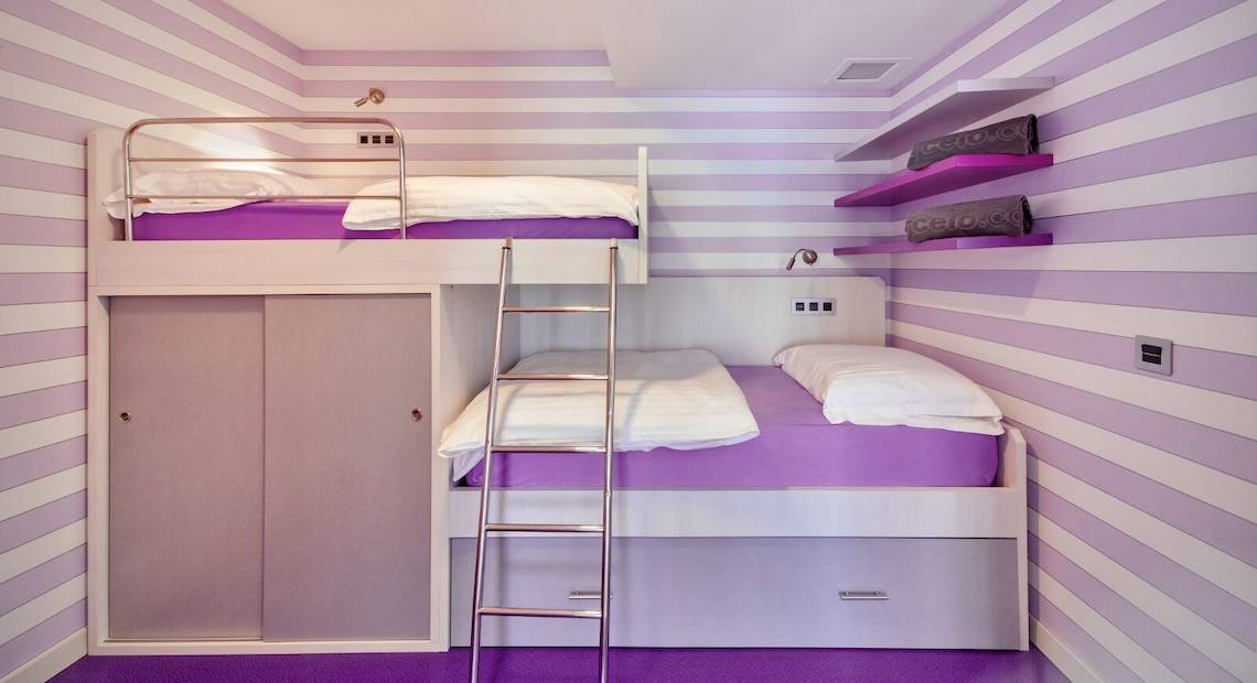 Doppelstockbett in einem Zimmer im Barcelo Fuerteventura Mar Hotel mit lila und weißen Wänden.