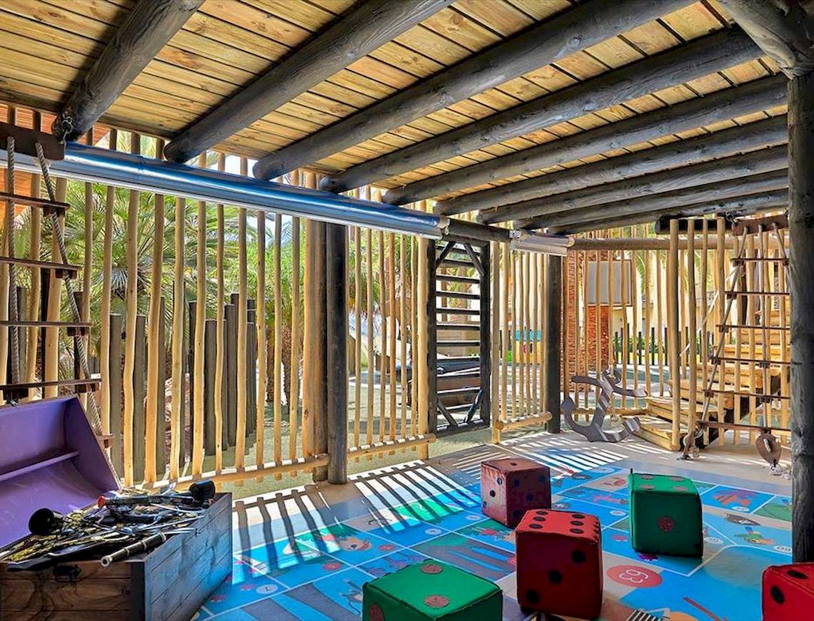 Kinderspielplatz im Barcelo Fuerteventura Mar Hotel mit Holzstrukturen, Würfeln und Spielzeugkiste.