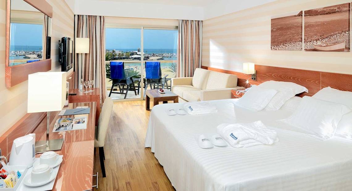 Hotelzimmer im Barcelo Fuerteventura Mar mit Meerblick, Doppelbett, Balkon und modernen Möbeln.