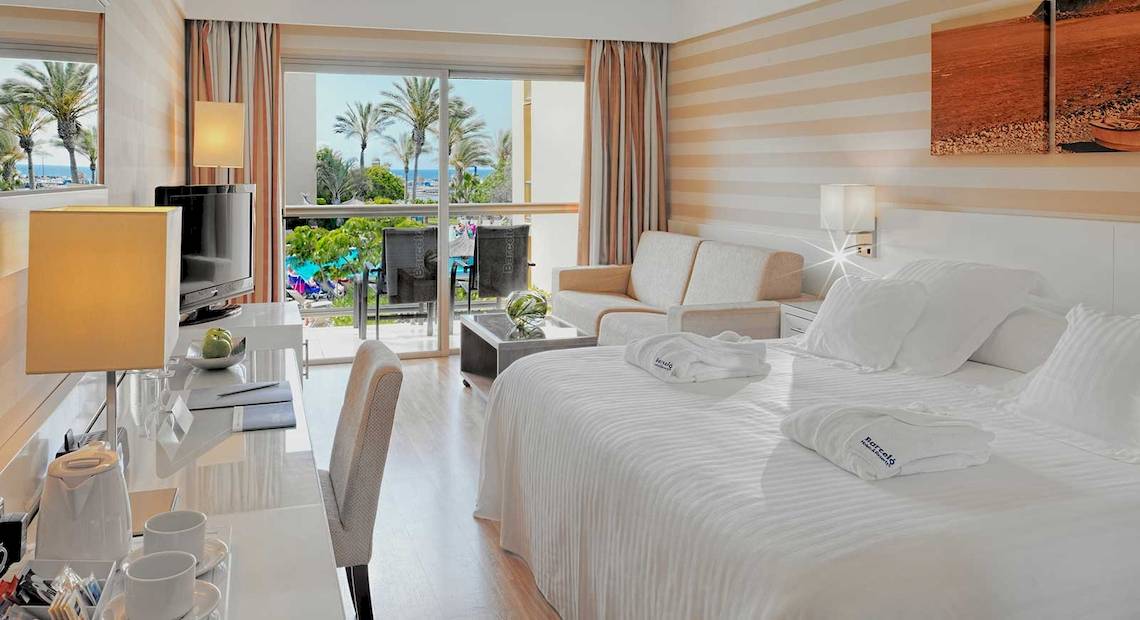 Innenansicht eines Hotelzimmers im Barcelo Fuerteventura Mar, mit Blick auf die Terrasse und das Meer.