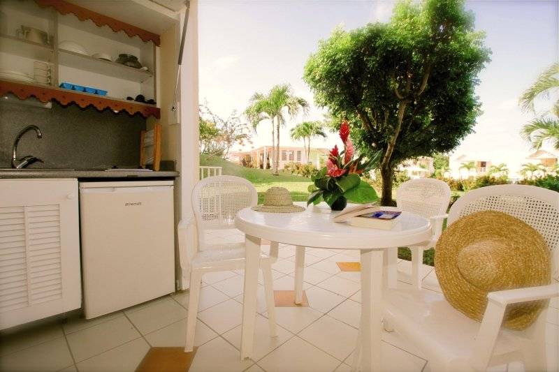 Terrasse des Karibea Sainte Luce Hotels mit Tisch, Stühlen und Blick auf Landschaft