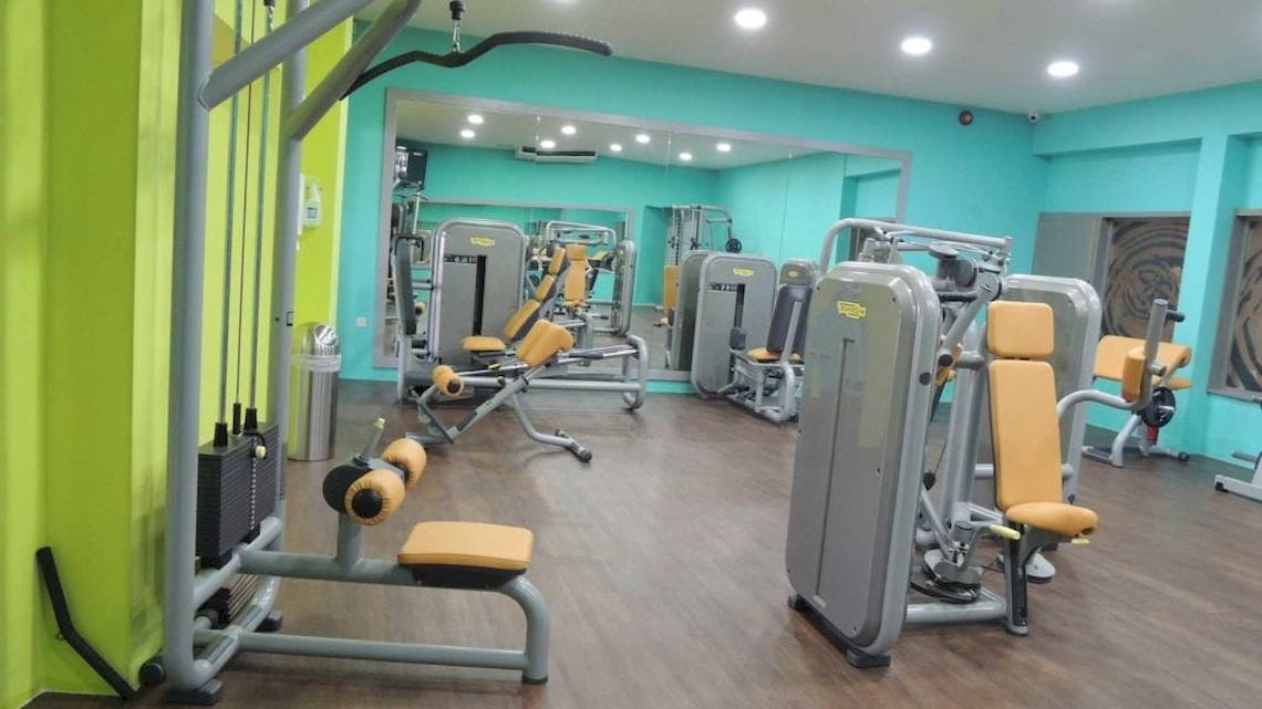 Fitnessstudio im Seashells Resort at Suncrest mit blauen Wänden und gelben Trainingsgeräten.