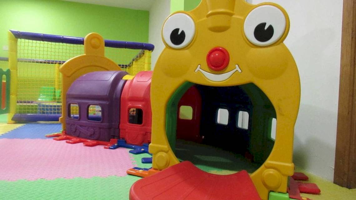 Kinderspielplatz im AX Odycy Hotel mit bunten Spielzeugzügen und einem großen gelben Spielzeugzug.