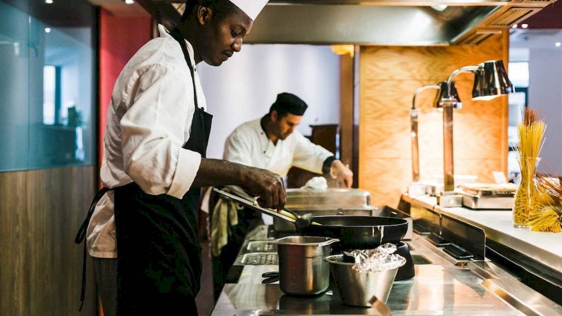 Koch in der Küche des AX Odycy Hotels, der Essen zubereitet.