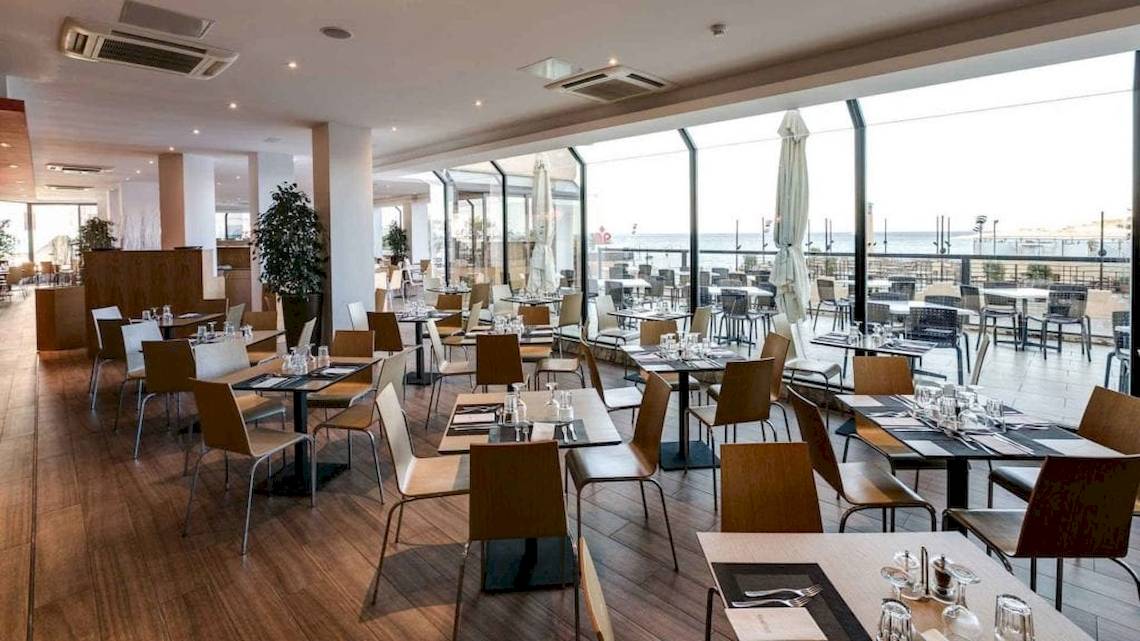Innenansicht des Restaurants im AX Odycy Hotel mit Blick auf den Ozean.