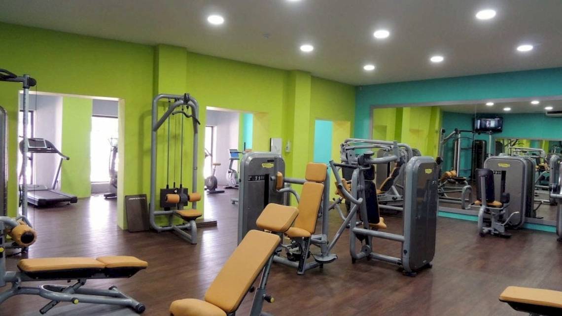 Fitnessstudio im Seashells Resort mit grünen Wänden und verschiedenen Trainingsgeräten.