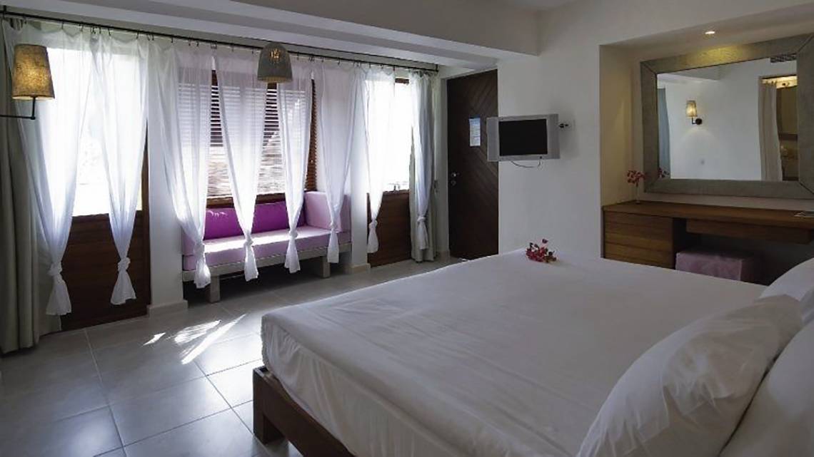 Schlafzimmer im Hillside Beach Club Hotel mit großem Bett, Fenstern und Wanddekor