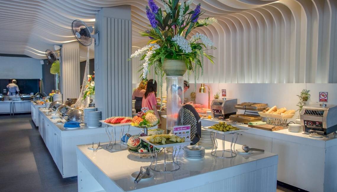 Frühstücksbuffet im Beyond Resort Krabi mit verschiedenen Speisen, Tellern und Dekorationen.