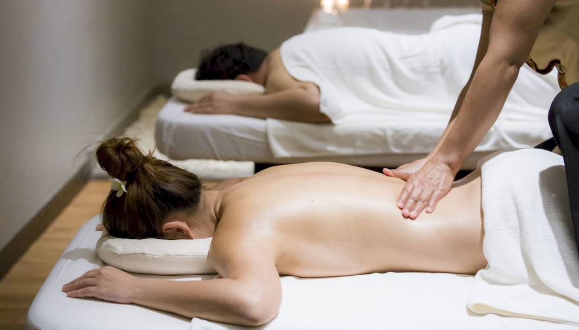 Massagebehandlung im Beyond Resort Krabi, bei der eine Frau Rückenmassage bekommt.