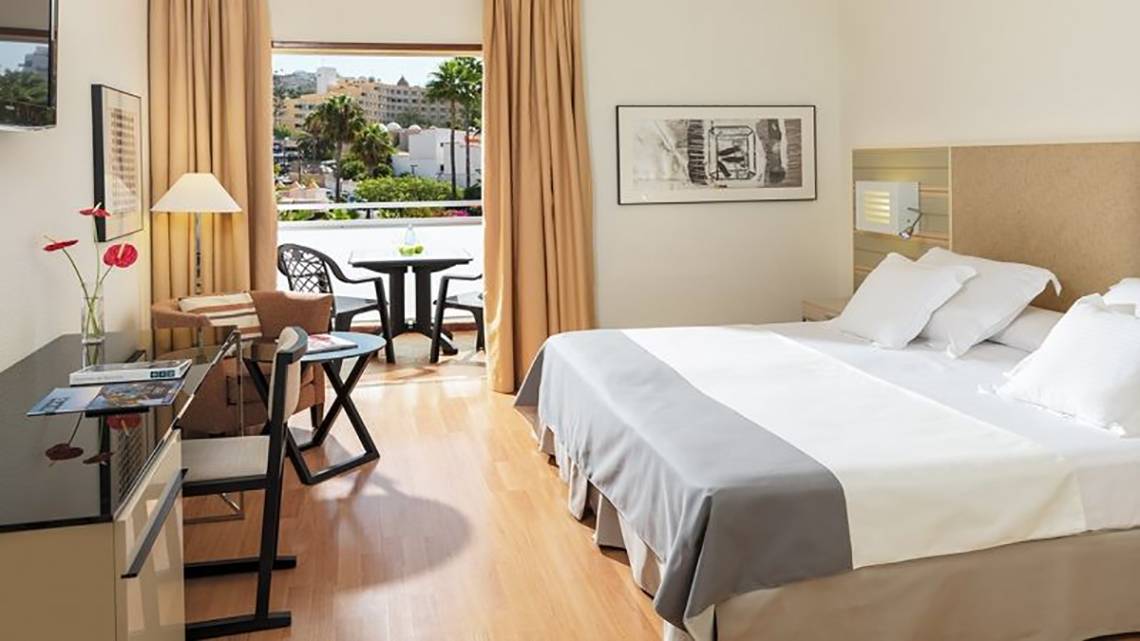 H10 Gran Tinerfe Hotelzimmer mit Balkon, Bett, Tisch und Stühlen.