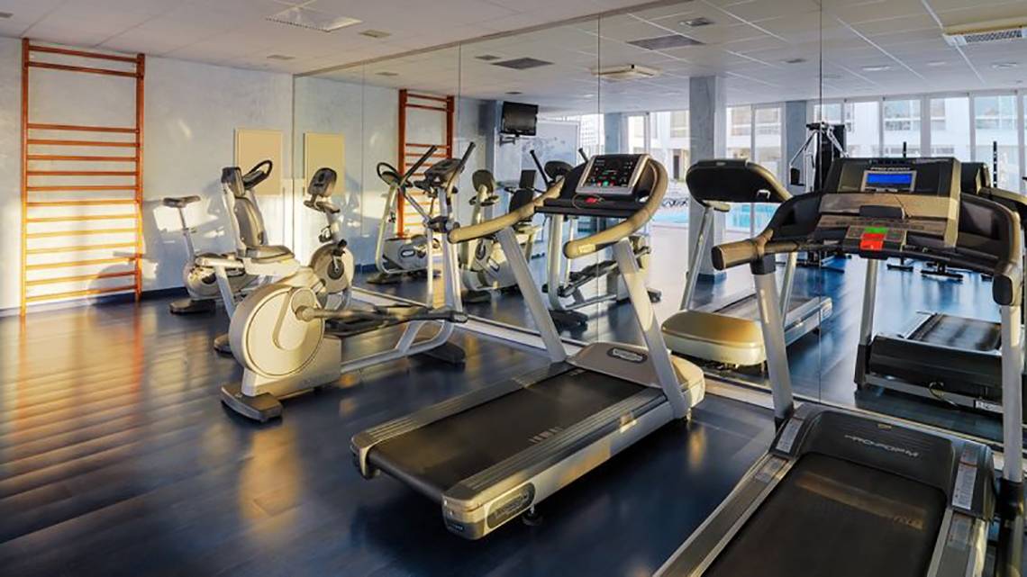 Fitnessraum im H10 Gran Tinerfe Hotel mit Laufbändern, Fahrradtrainern und anderen Geräten.