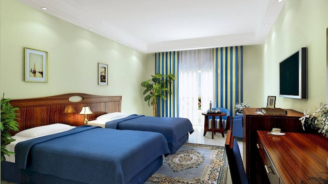 Doppelzimmer im Stella Gardens Resort & Spa Makadi Bay mit zwei Betten, Schreibtisch, Fernseher und Pflanzen.