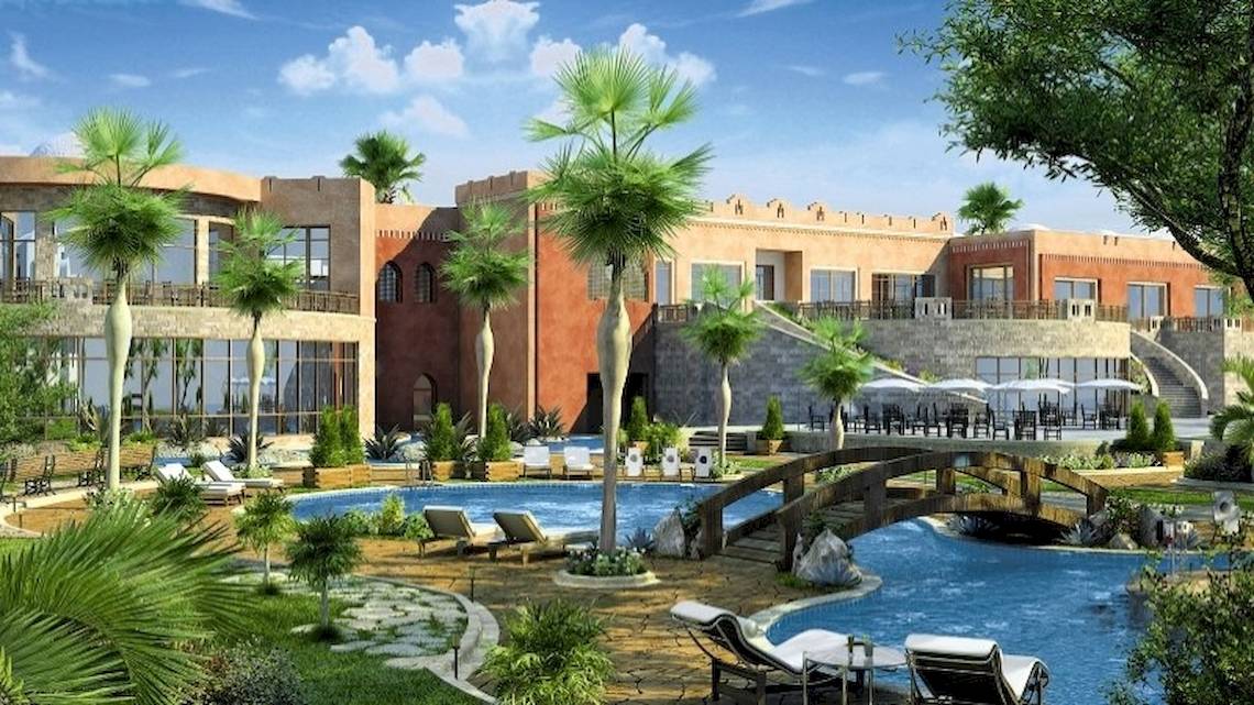 Luftaufnahme des Stella Gardens Resort & Spa Makadi Bay mit Swimmingpool, Liegestühlen und Palmen.