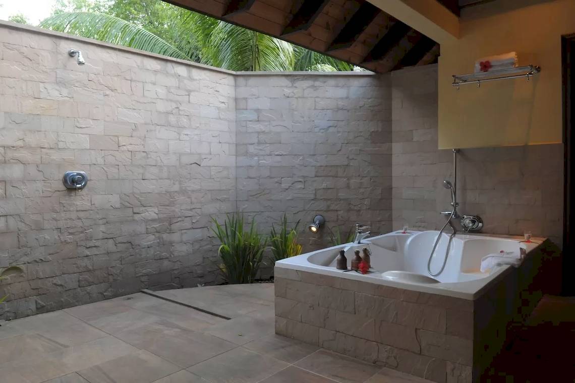 Außenbadewanne im Cerf Island Resort mit Steinwänden und Pflanzen.